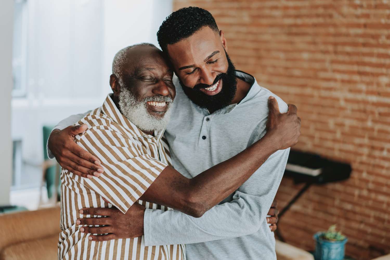Adult son hugging father at home