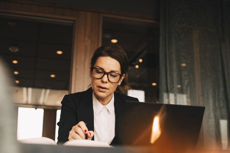 Low angle view of female loan officer reading book