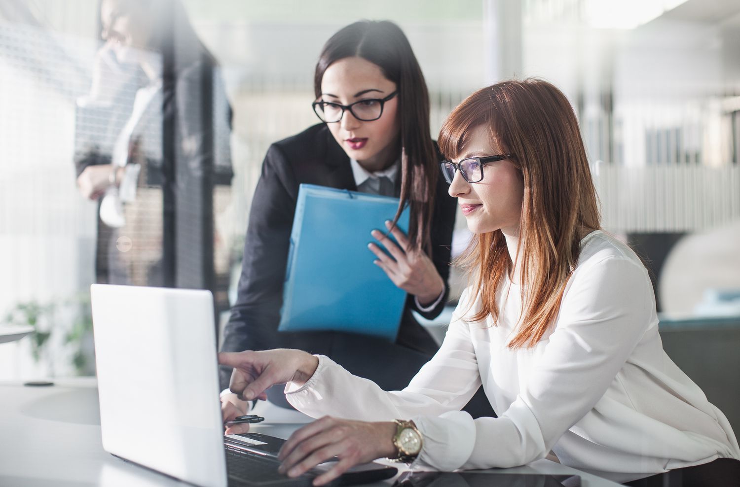 Young women finance workers looking at computer screen