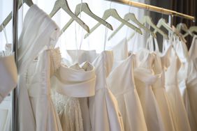 A rack of wedding dresses on hangers in a shop. 