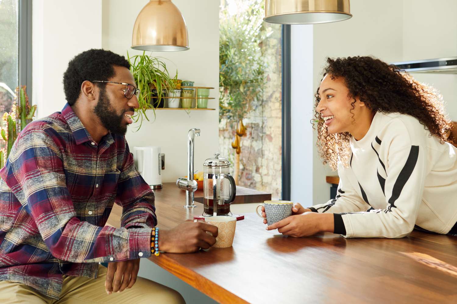 Two friends having coffee in kitchen