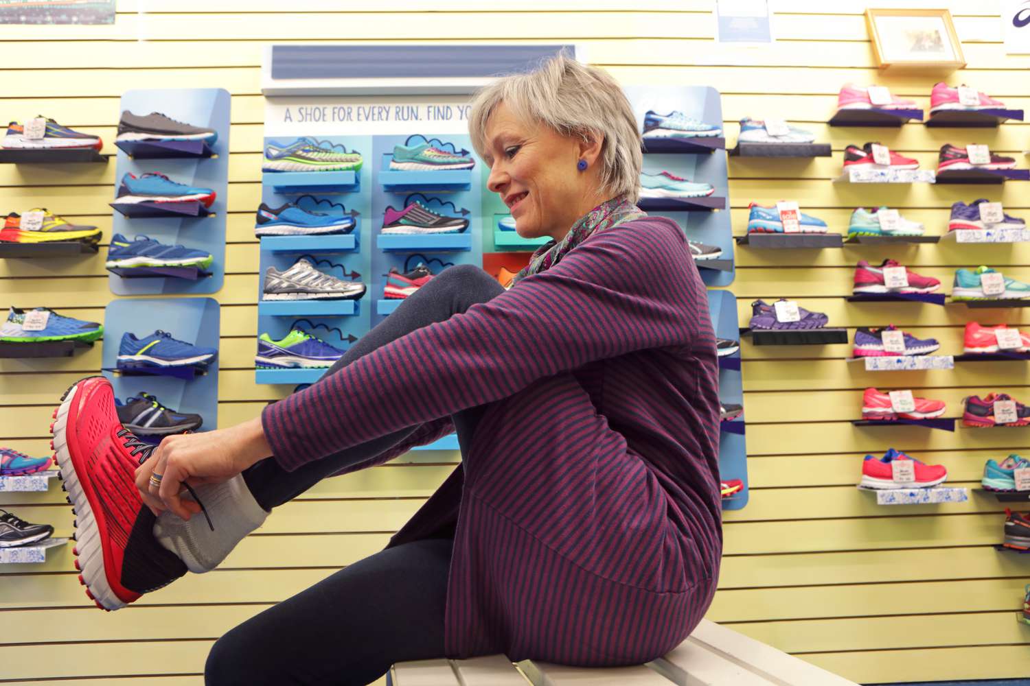 A woman tries on sneakers in a store