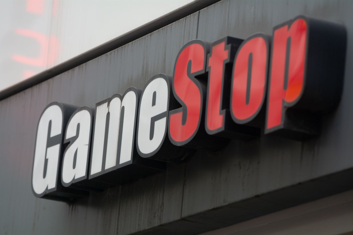 The red and white GameStop logo is seen on the side of a building.