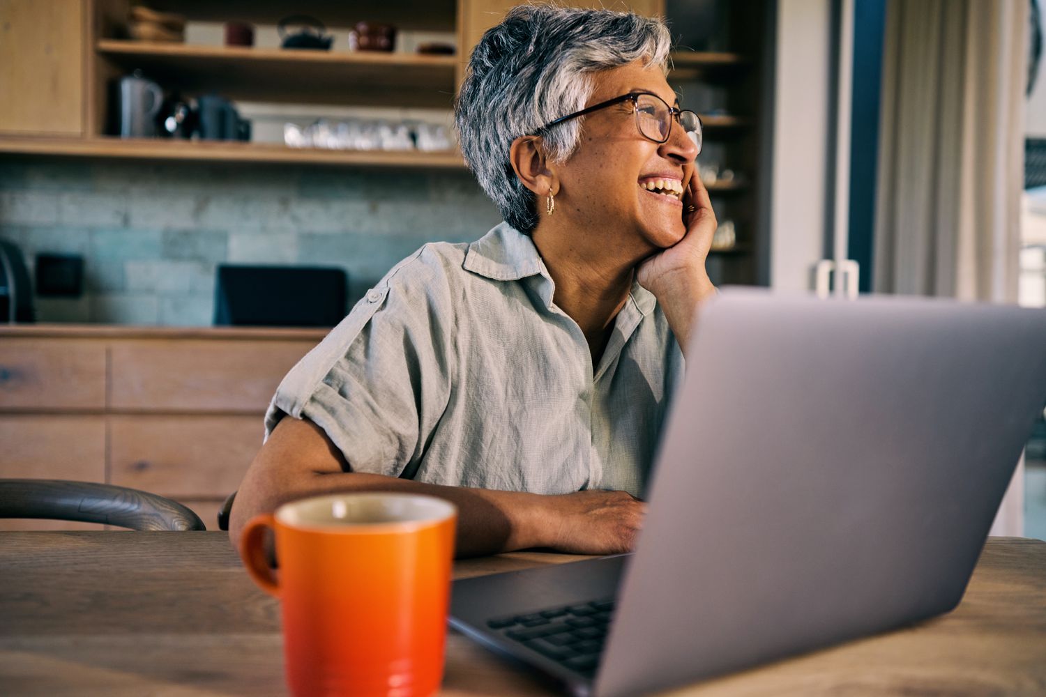 Smiling worker in kitchen with computer