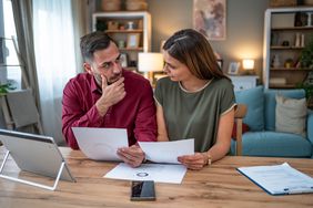 Two people looking at paperwork at home