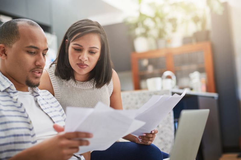 A couple reviewing bills, looking concerned