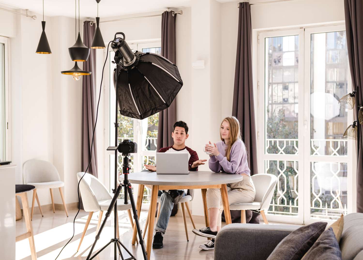 Video bloggers making a YouTube video with a professional camera on a tripod at home.