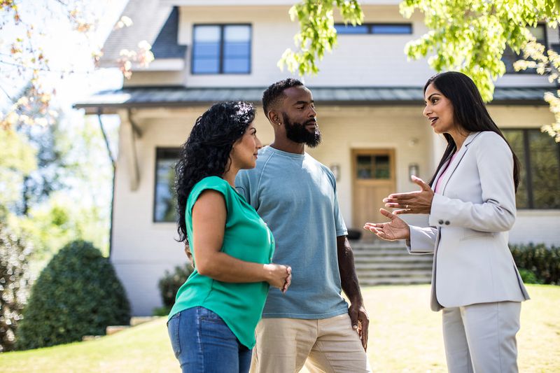 Couple Meeting With Real Estate Agent in Front of Home