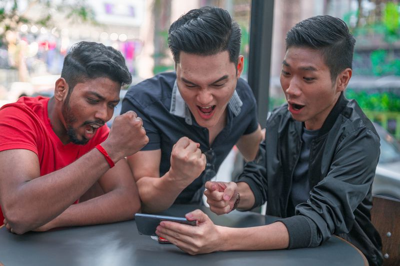 Group of friends playing mobile games on smartphone