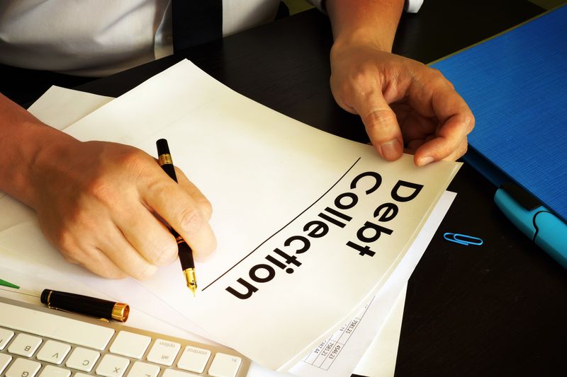 A person from a debt collection agency is preparing paperwork.