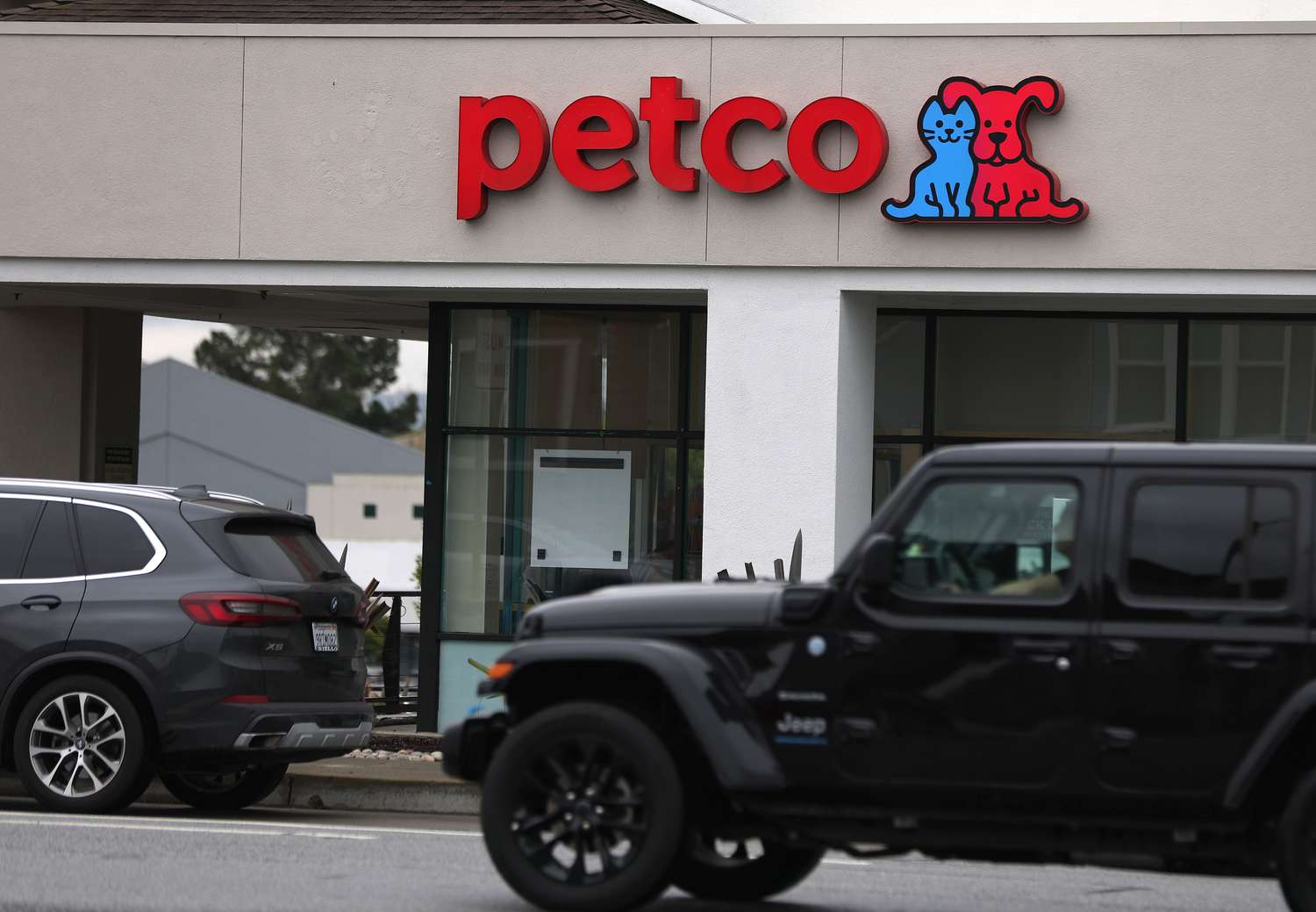 Cars are seen on the street in front of a Petco store.