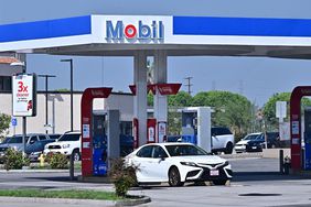 A white car is seen parked at a Mobil gas station.