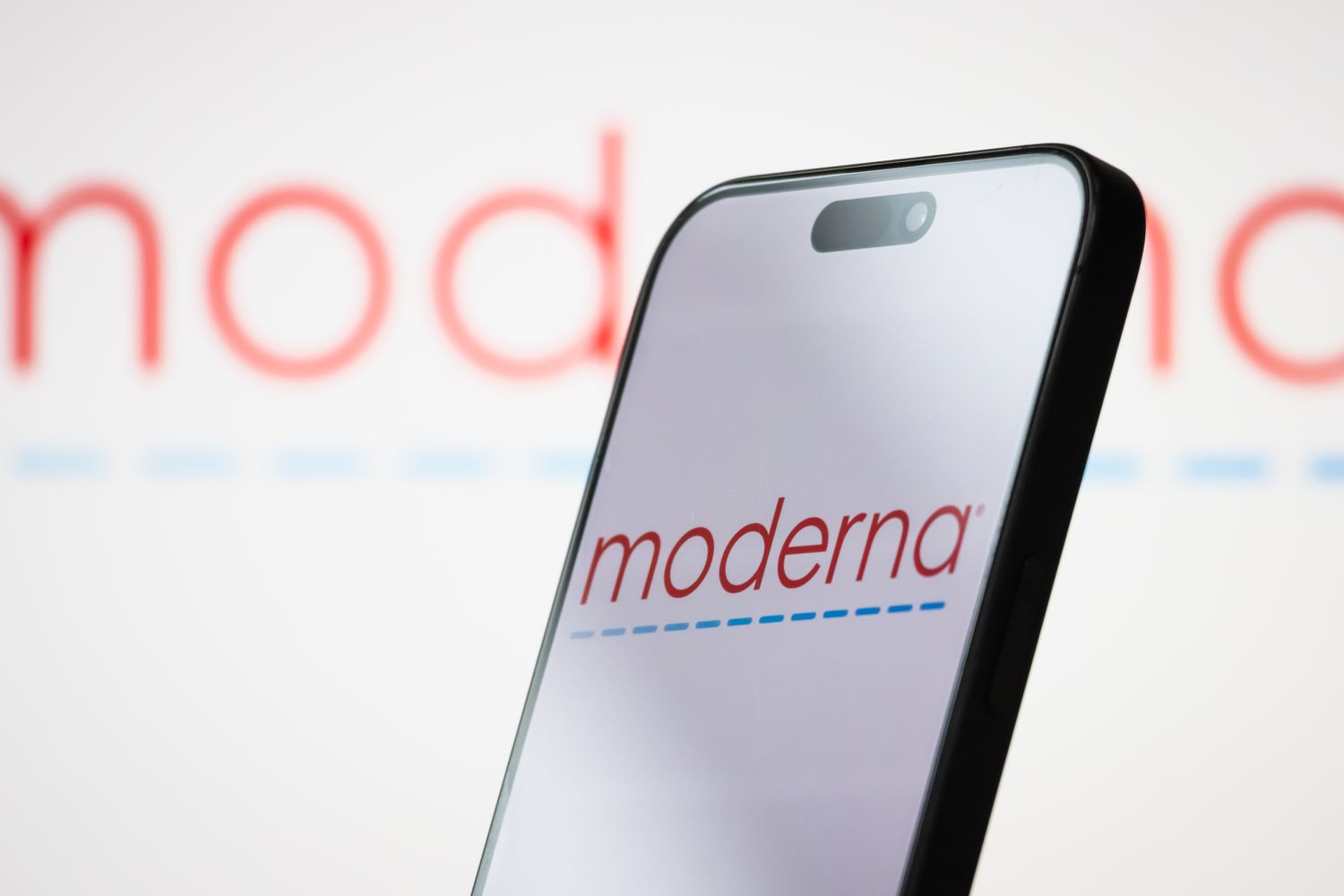 The logo of Moderna, Inc. is displayed on a smartphone screen, with the company's branding visible in the background