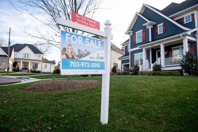 House with a For Sale sign in the front yard