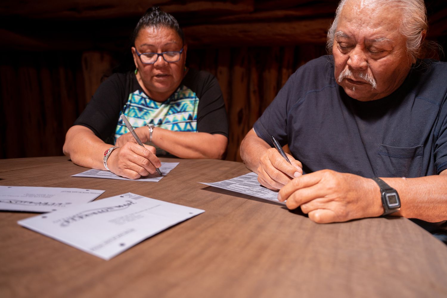 Navajo Senior Couple Sitting At A Table reviewing paperwork
