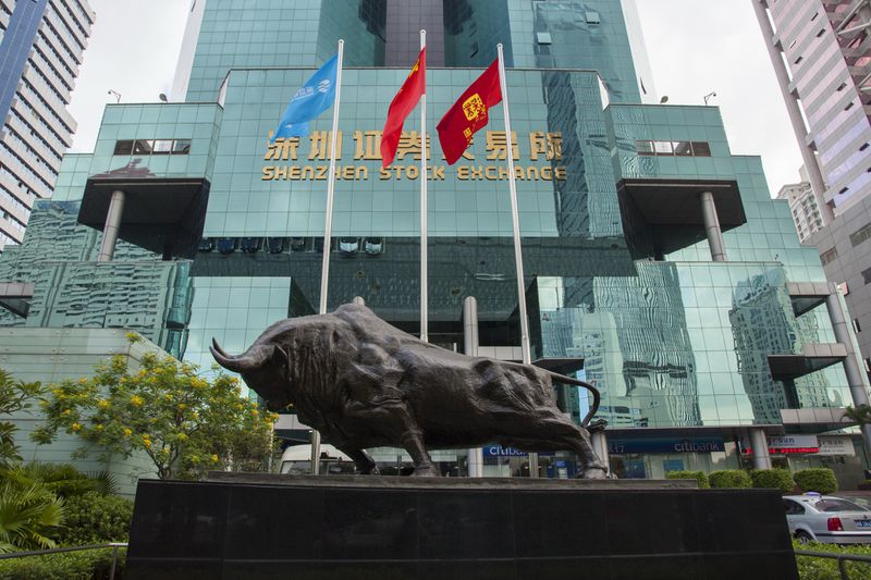 The Shenzhen stock exchange building with a statue of a bull in front