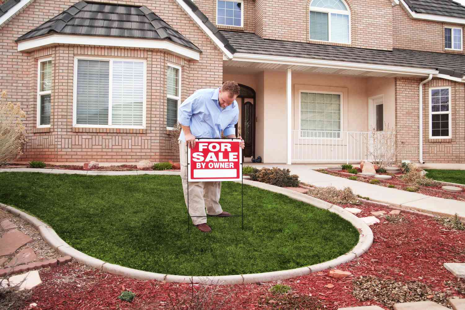 Homeowner putting a "For Sale by Owner" sign in the front yard to attract potential buyers.