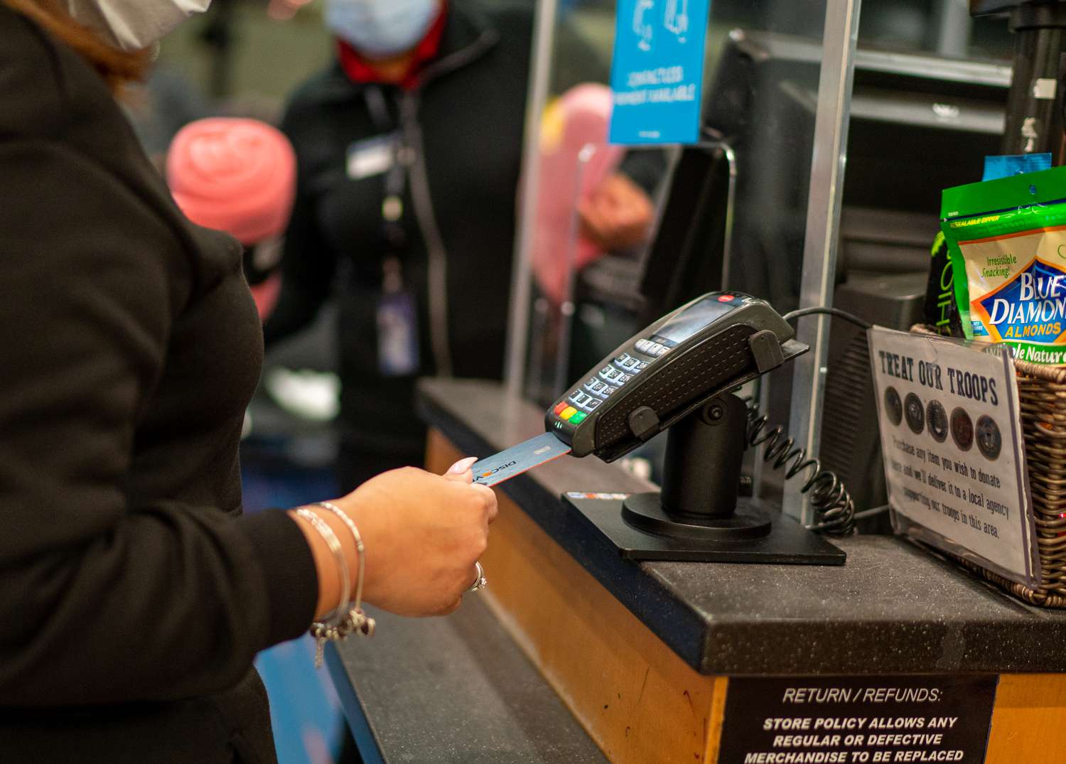 Woman inserts her card into a credit card reader.