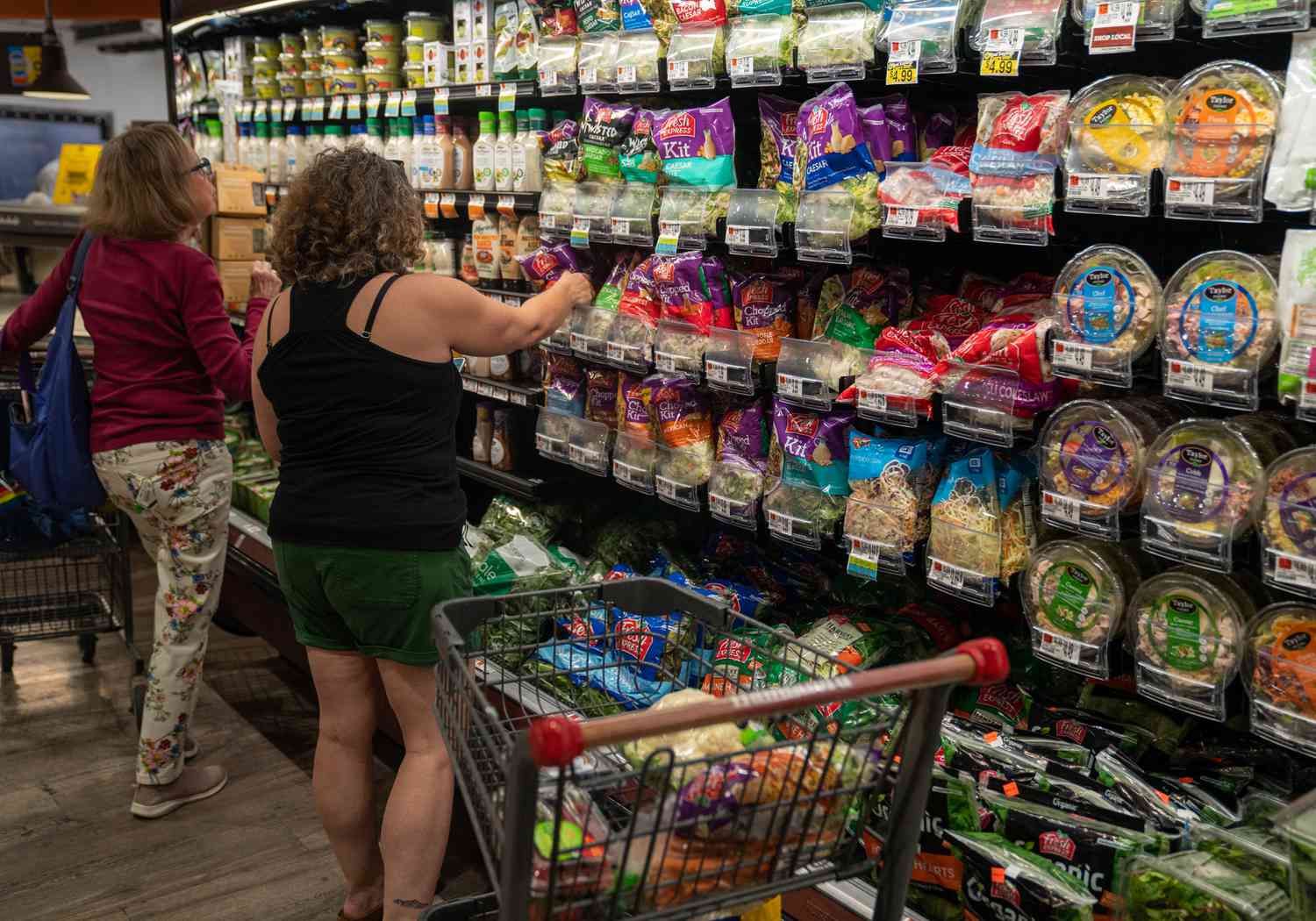 Food shoppers search for vegetables July 1, 2023 at the Hannaford supermarket in South Burlington, Vermont. The inflation rate for food and other durable goods was 9.7% in May, 2023.