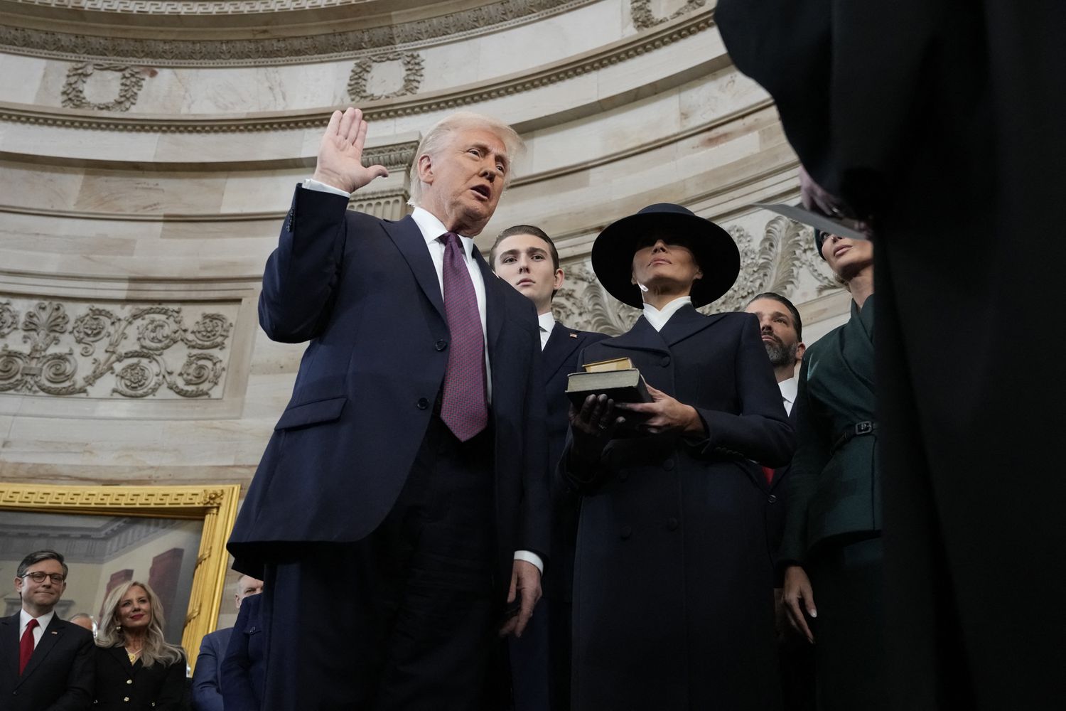 Donald Trump is sworn in as the 47th president of the United States by Chief Justice John Roberts as Melania Trump holds the Bible during the 60th Presidential Inauguration in the Rotunda of the U.S. Capitol in Washington, Monday, Jan. 20, 2025.