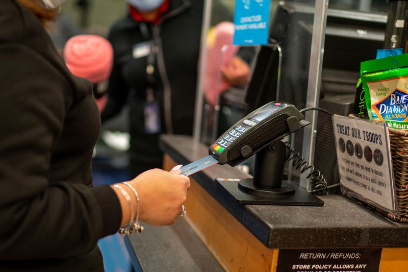 Woman inserts a credit card into a reader.