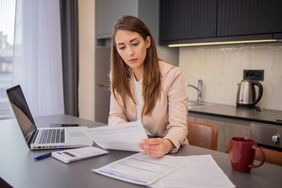 A woman with papers and a computer