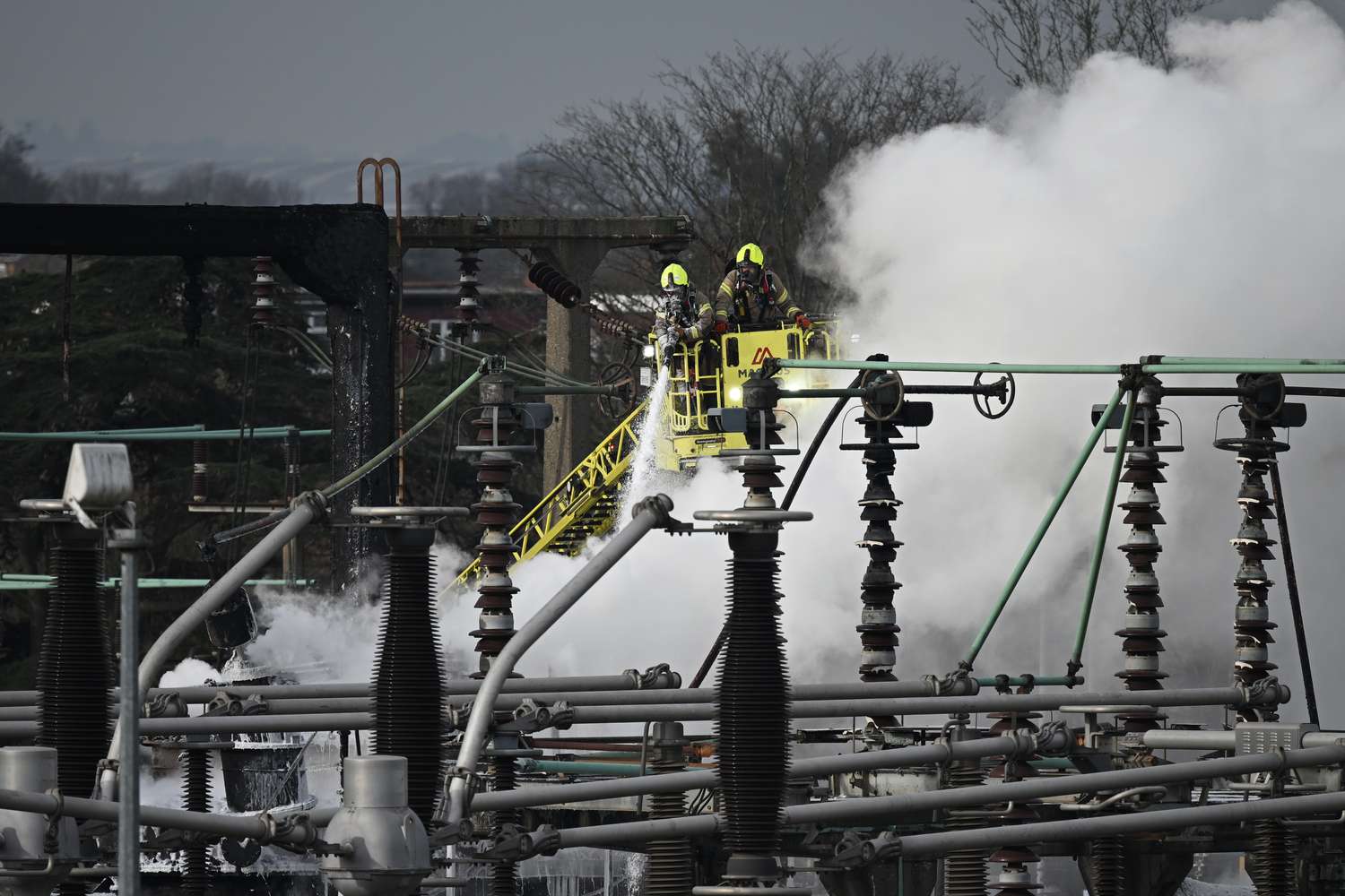 Members of the fire brigade attend the scene after a major fire at an electrical substation at Heathrow airport. 