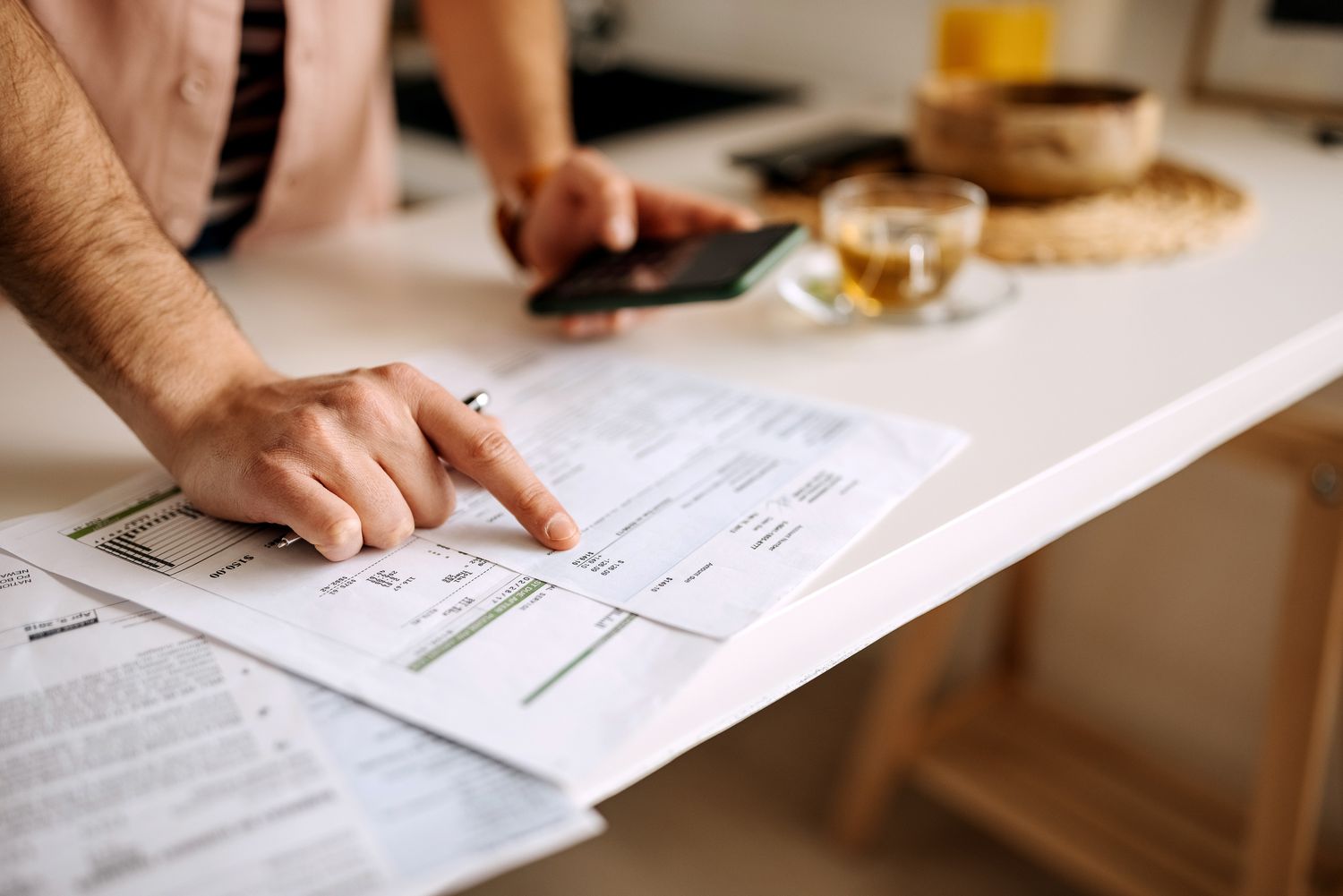 Man using calculator on the phone to calculate expenses