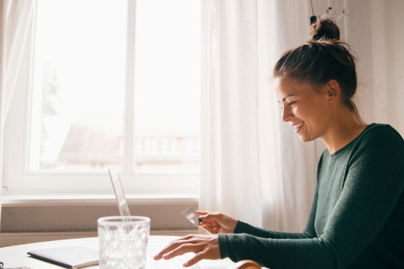 A shopper uses her credit card to make an online purchase.