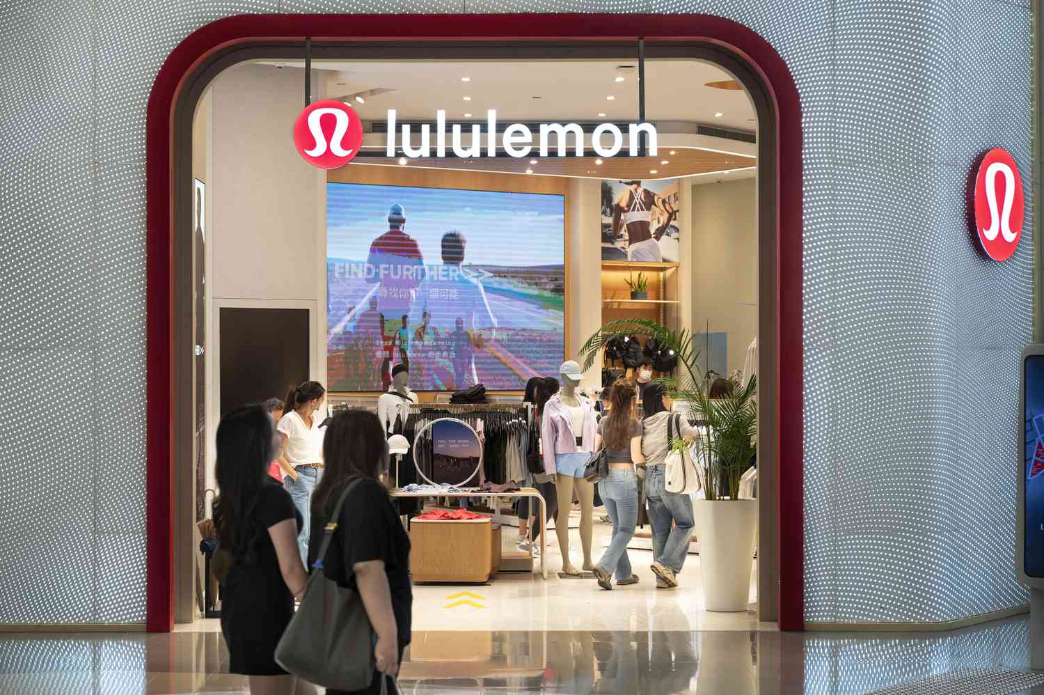 People walk near a Lululemon store. 