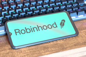 Robinhood logo displayed on a smartphone screen lying on a keyboard