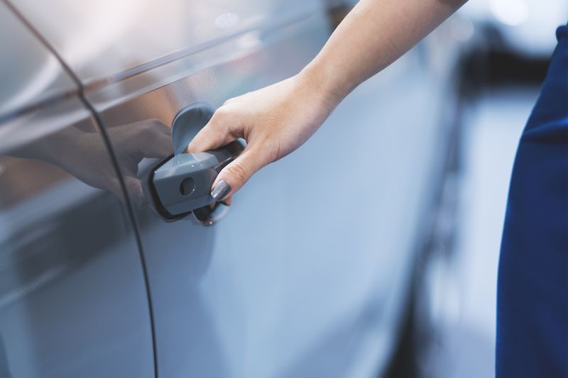 A woman's hand opening a car door