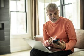 Man looking at laptop and mobile