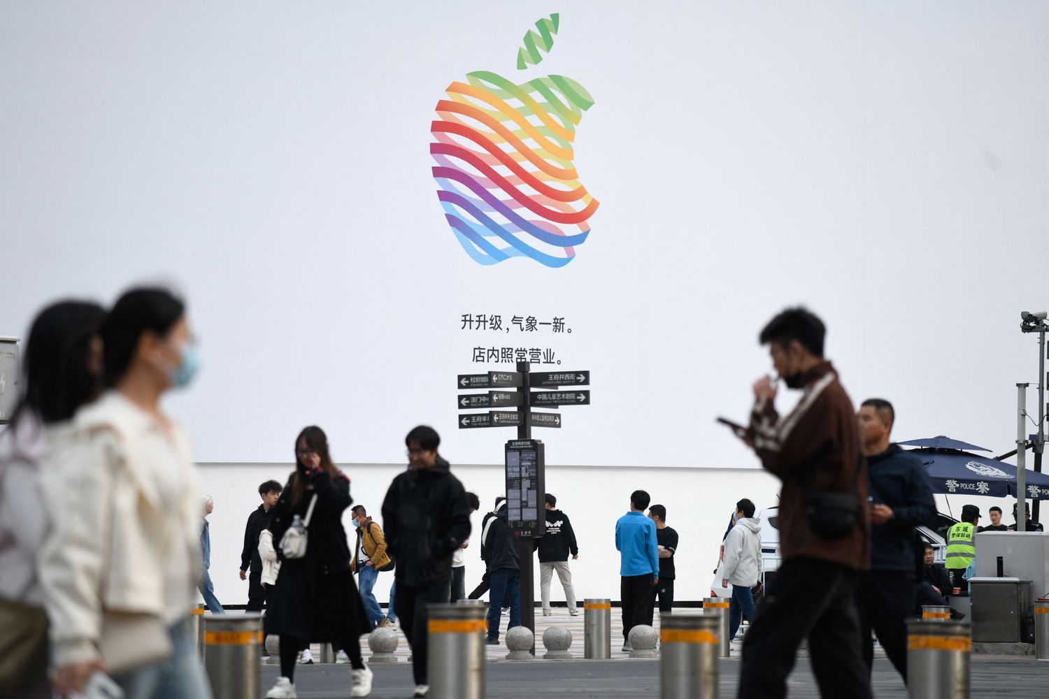 People walk past an Apple Store along a shopping street in Beijing.
