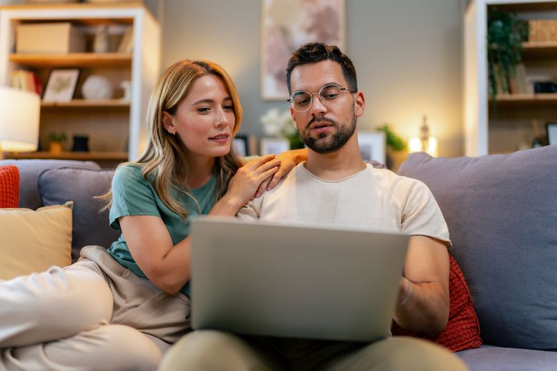 Young couple reviewing their finances while using their laptop