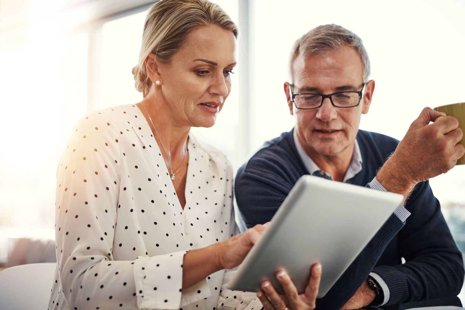 A adult couple look at a tablet together as they discuss the possiblity of using an annuity to help fund their retirement.