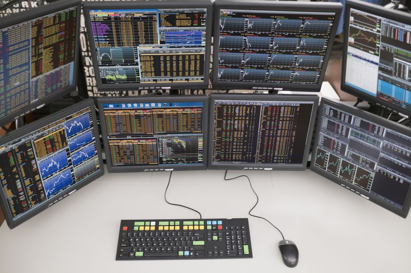 A desk with arrangement of computer monitors.