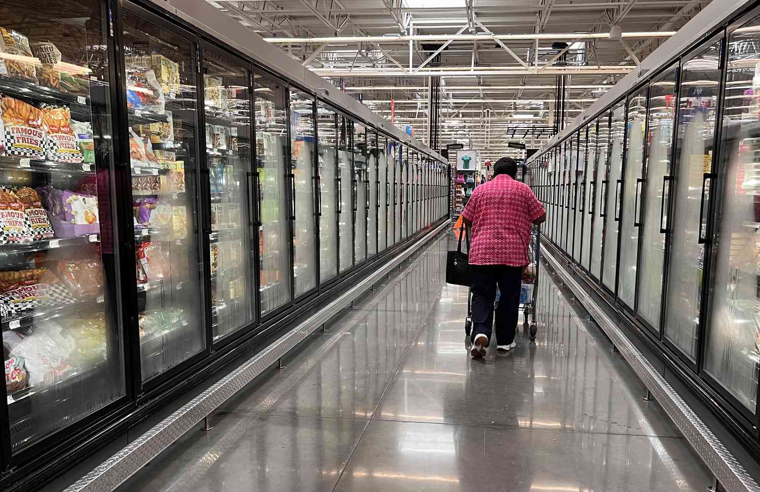 A customer walks down an aisle at Walmart. 