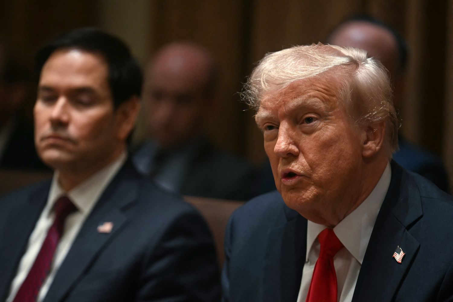 US President Donald Trump speaks as Secretary of State Marco Rubio (L) looks on during a cabinet meeting at the White House in Washington, DC, on February 26, 2025. 