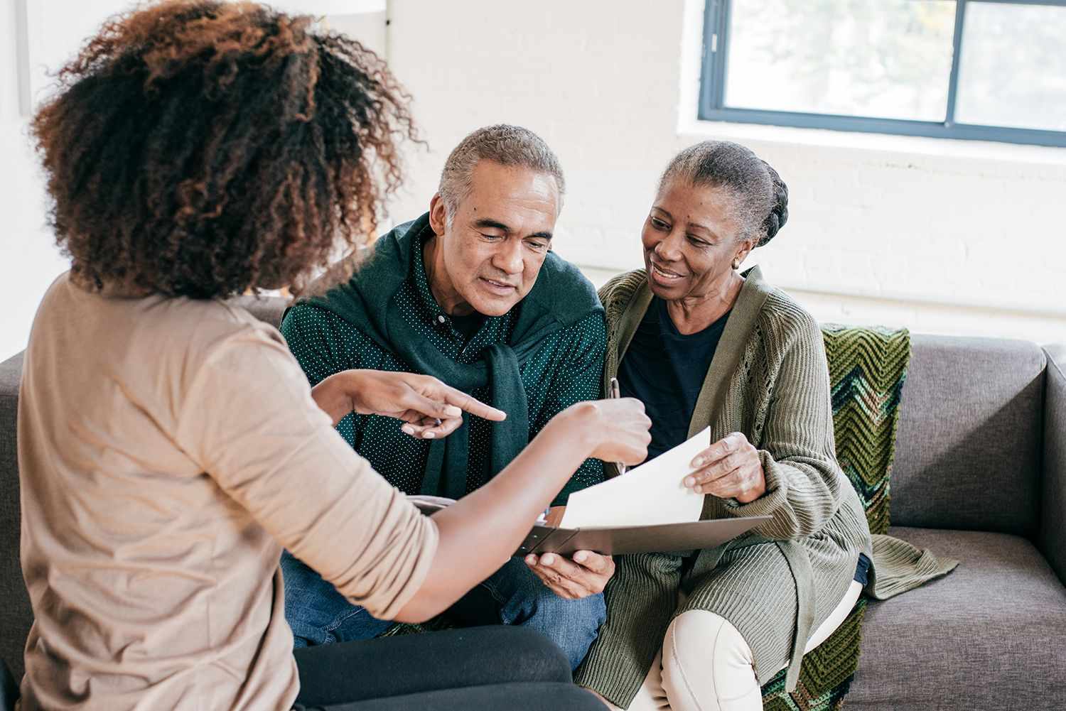 A woman shows papers to an older couple