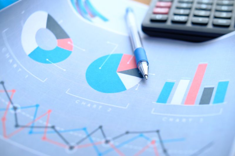 A pen, chart and calculator on table.