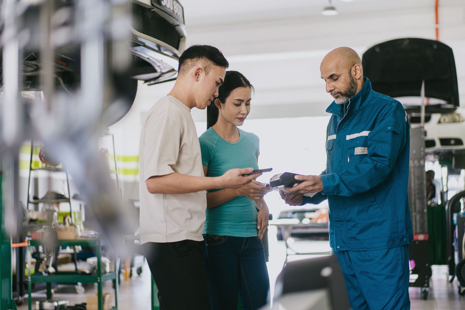 Couple paying for car repair at a garage with a credit card