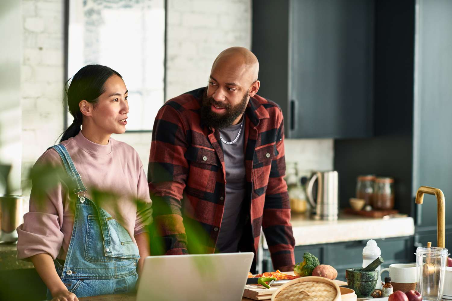 Multiracial couple discussing in the kitchen