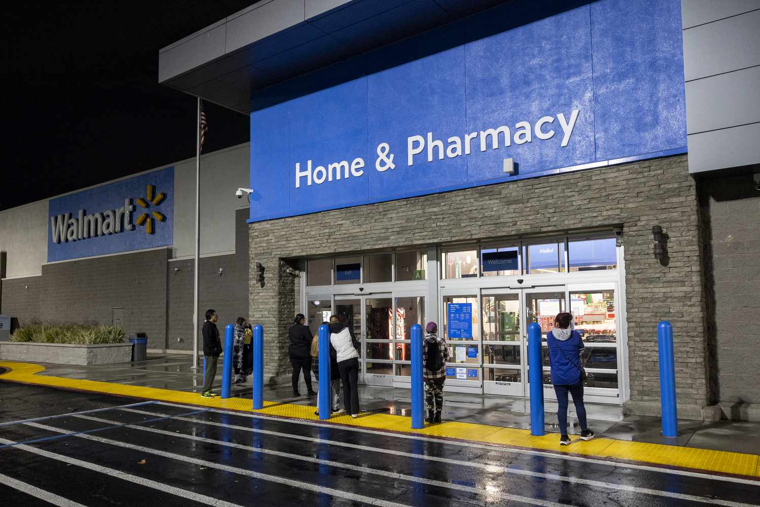 People waiting near a Walmart store entrance