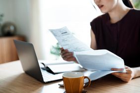 woman making financial plan and planning budget as she go through her financial bills, tax and expenses at home