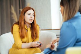 Two women in armchairs are sitting and talking. 