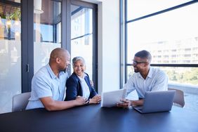 Mature couple smiling during a meeting with their financial advisor about CD rates