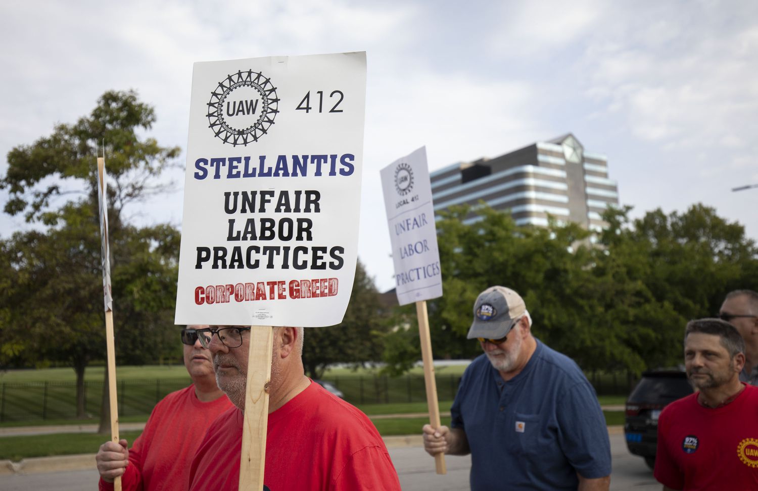 People hold signs on the picket line of the UAW Big Three strike. 