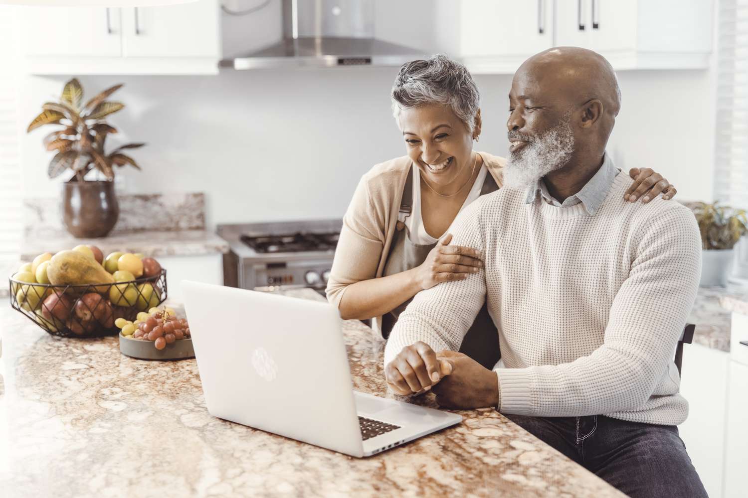 Couple in kitchen in front of a computer