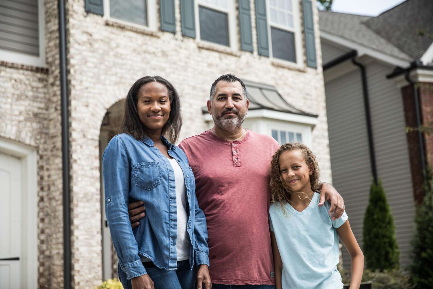 Family stands outside of the home they purchased with a 15-year mortgage